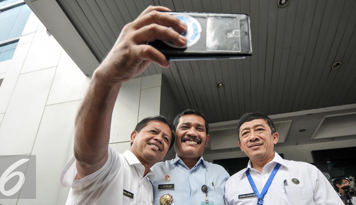 Mantan Kalapas Nusakambangan, Liberty Sitinjak tersenyum saat berselfie usai memenuhi panggilan BNN, Jakarta, Senin (8/8). BNN memanggil Liberty Sitinjak untuk mengusut testimoni Freddy Budiman yang diungkap Haris Azhar. (Liputan6.com/Yoppy Renato)