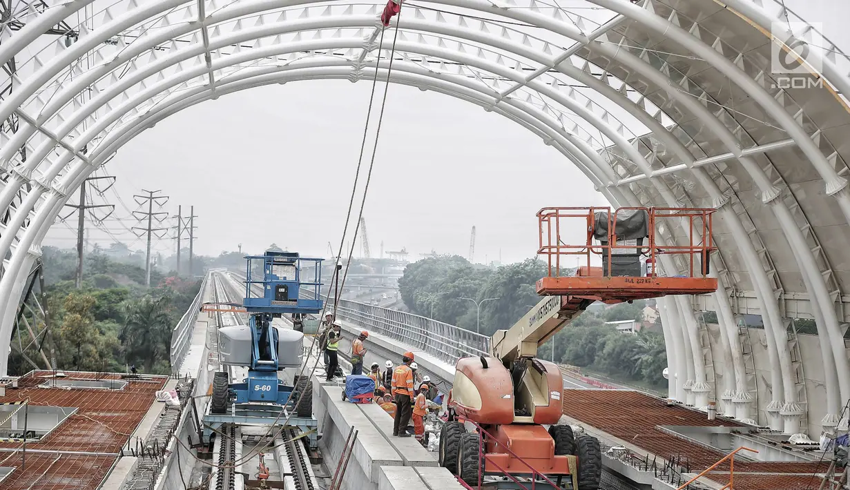 Pekerja menyelesaikan proyek pembangunan Light Rail Transit (LRT) Jabodebek di Stasiun LRT TMII, Jakarta, Senin (14/1). Stasiun LRT TMII dibangun dua lantai yang terdiri dari komersial dan pembelian tiket. (Liputan6.com/Faizal Fanani)