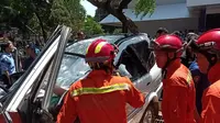 Mobil ringsek setelah tertimpa pohon tumbang di Universitas Pancasila, Jakarta Selatan. (Merdeka.com)