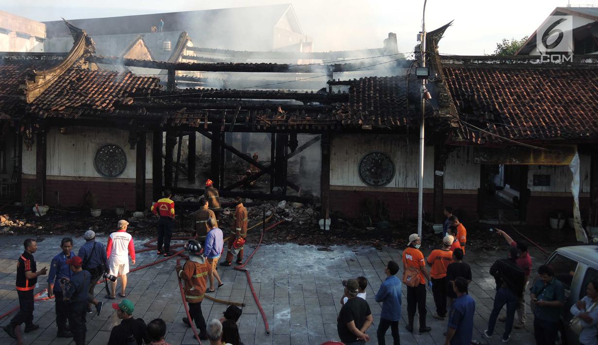 Petugas pemadam kebakaran dan warga berkumpul di lokasi kebakaran yang melanda kompleks Kelenteng Tay Kak Sie di Gang Lombok, Semarang, Kamis (21/3). Dilaporkan satu orang tewas dalam insiden kebakaran ini. (Liputan6.com/Gholib)