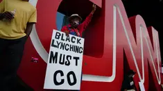 Orang-orang menggelar aksi protes di kantor pusat CNN di Atlanta, Georgia, Jumat (29/5/2020). Massa yang mengecam kematian George Floyd (46) oleh polisi melakukan vandalisme dan perusakan gedung CNN pusat. (Elijah Nouvelage/Getty Images/AFP)