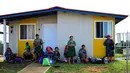 Masyarakat adat Gunas menunggu di luar rumah baru mereka di Nuevo Carti, Guna Yala Comarca, di pantai Karibia di daratan Panama, pada 29 Mei 2024. (MARTIN BERNETTI / AFP)