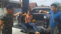 Tersangka pembunuh anak tiri setelah ditembak personel Polresta Pekanbaru. (Liputan6.com/M Syukur)