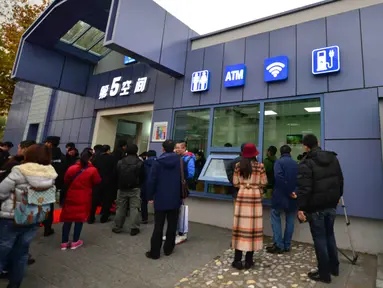 Warga mengantre di luar toilet umum pertama yang dilengkapi Wi-fi, mesin ATM hingga tempat pengisian energi untuk ponsel dan mobil listrik di Beijing, Kamis (19/11). Toilet ini juga akan dibuka di pinggiran kota Beijing dan kota lain.(CHINA OUT AFP PHOTO)