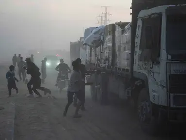 Warga Palestina berbondong-bondong menuju truk yang mengangkut bantuan dari Program Pangan Dunia (WFP) saat truk-truk tersebut melintasi Deir al-Balah di Gaza Tengah, Sabtu, 8 November 2025. Situasi kemanusiaan di Gaza, yang sebagian besar wilayahnya luluh lantak, masih memprihatinkan. (AP Photo/Abdel Kareem Hana)