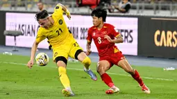 Pemain Malaysia, Dion Cools (kiri) berebut bola dengan pemain Vietnam, Nguyen Van Vi dalam laga Grup F Kualifikasi Piala Asia 2027 di Stadion Nasional Bukit Jalil, Kuala Lumpur, Malaysia, Selasa (10/06/2025). (AP Photo/Vincent Thian)