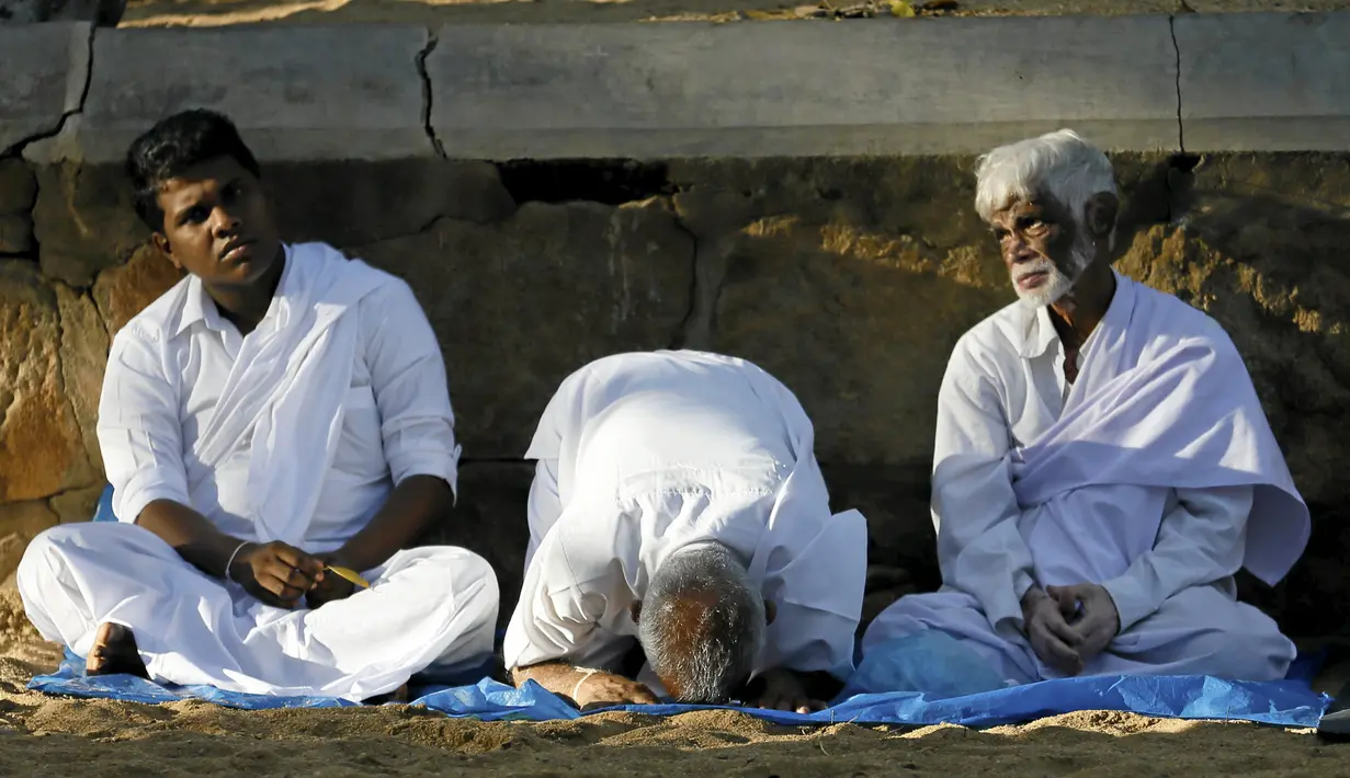 Umat Buddha berdoa di depan Sri Maha Bodhi (the sacred Bo tree of Anuradhapura) pada hari Poya untuk menandai kunjungan kedua Buddha ke Sri Lanka (21/4). Hari Poya dijadikan hari libur Nasional bagi warga Sri Lanka. (REUTERS/Dinuka Liyanawatte)