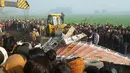 Sejumlah orang berkumpul di lokasi kecelakaan antara bus sekolah dan truk di Etah, negara bagian Uttar Pradesh, India, Kamis (19/1). Dalam tragedi tersebut sedikitnya 15 anak dan pengemudi bus tewas serta puluhan lainnya terluka. (AFP PHOTO/STR)