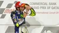 Pebalap Yamaha, Valentino Rossi, mencium trofi seusai memenangi MotoGP Qatar 2015. (EPA/Stringer)