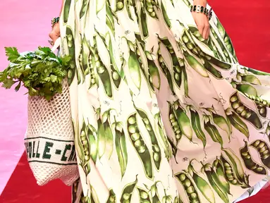 Model berjalan membawa tas besar mirip tas pasar dan mengisinya dengan sayuran untuk koleksi Dolce & Gabbana Spring/Summer 2018 di Milan Fashion Week, Minggu (24/9). (AFP PHOTO / Andreas SOLARO)