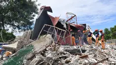 Tim penyelamat mencari tiga orang yang dilaporkan hilang di bawah reruntuhan bangunan yang runtuh di Kota Bogo, Filipina pada 1 Oktober 2025. (TED ALJIBE/AFP)