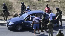 Anggota Tentara Ekuador memberhentikan sebuah kendaraan di pinggiran Penjara Regional ke-8 di Guayaquil, Ekuador (4/11/2022). Enam polisi terluka Kamis (4/11) dalam kerusuhan penjara terbaru yang melanda Ekuador, karena negara itu dicengkeram oleh kekerasan yang dipersalahkan pada kelompok kejahatan terorganisir yang mengobarkan perang narkoba yang mematikan. (AFP/Rodrigo Buendia)