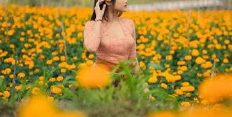 Fuji baru saja mengunggah potret dirinya di tengah ladang bunga warna orange yang indah. Bunga tersebut senada dengan warna kebaya yang ia kenakan. [@fuji_an]