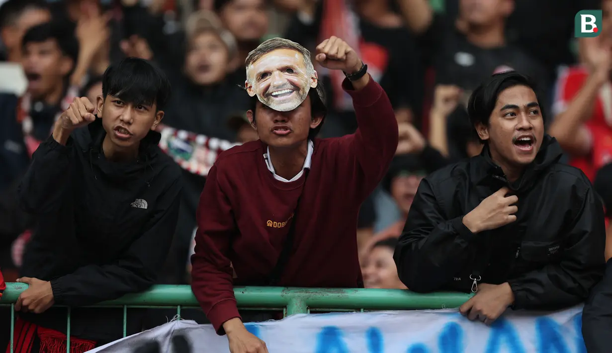 <p>Tiga orang pendukung Persija Jakarta, di antaranya mengenakan topeng Thomas Doll (tengah) pada laga pekan ke-11 BRI Liga 1 2023/2024 antara Persija Jakarta menghadapi Persib Bandung di Stadion Patriot Candrabhaga, Bekasi, Sabtu (2/9/2023). (Bola.com/Abdul Aziz)</p>