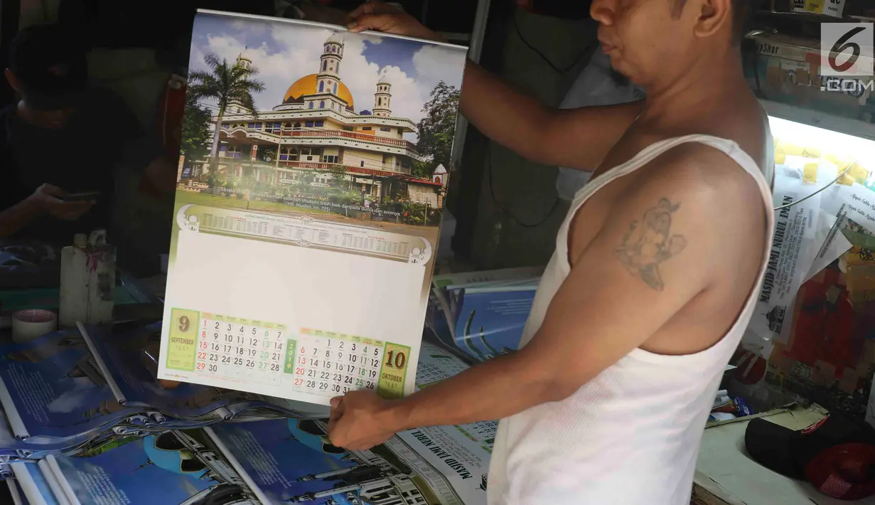 Pekerja menunjukkan kalender tahun 2019 di kawasan Senen, Jakarta, Jumat (7/12). Menjelang berakhirnya tahun 2018, produksi kalender di kawasan pusat percetakan tersebut meningkat 40 persen. (Liputan6.com/Immanuel Antonius)