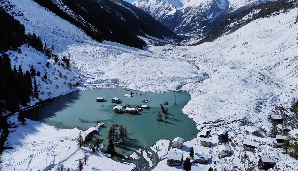 Pemandangan udara menunjukkan Desa Blatten yang sebagian terendam banjir setelah hujan salju baru-baru ini, lima bulan setelah tanah longsor menghancurkan desa tersebut, Blatten, Swiss, pada Selasa 28 Oktober 2025. Lima bulan setelah terkubur longsoran es, Desa Blatten di Swiss, perlahan muncul kembali dari timbunan puing-puing, dan lumpur yang diakibatkan oleh keruntuhan gletser. (AP Photo/Michael Probst)