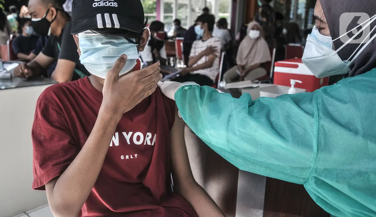 Ekspresi seorang anak saat menerima vaksin Covid-19 dalam program Vaksinasi Keliling di RPTRA Pulo Besar, Sunter Jaya, Jakarta, Selasa (12/7/2021). Kementerian Kesehatan mengalokasi 20 juta dosis vaksin Covid-19 untuk anak usia 12-17 tahun yang diberikan secara bertahap (merdeka.com/Iqbal S Nugroho)