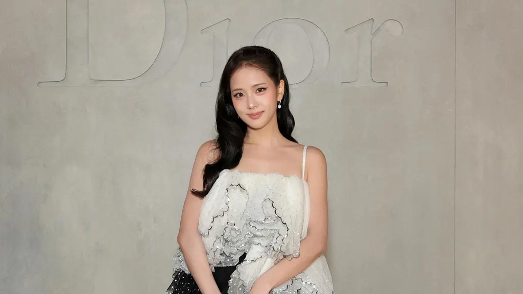 Jiso selalu tampil stunning, kali ini member Blackpink ini mengenakan atasan spagetti strap putih ruffle putih dengan bagian belakang menjuntai, dipadukan rok asymmetrical hitam polkadot. Dipadukan black pointed-toe pumps sambil membawa bucket bag hitam kecil dengan detail ornamen emas. [Dok. DIOR]