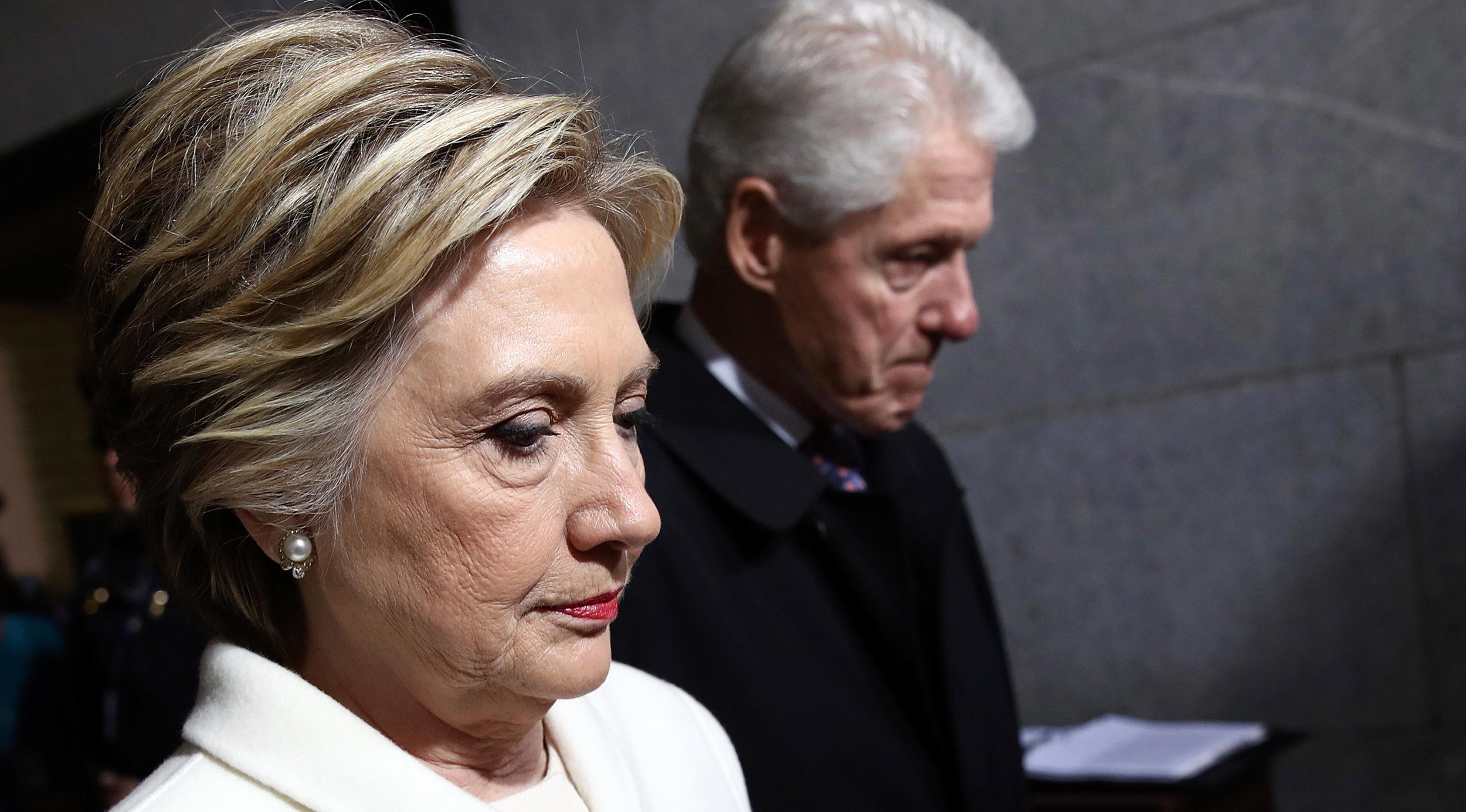 Mantan calon presiden dari partai Demokrat, Hillary Clinton berjalan dengan suaminya, Bill Clinton untuk menghadiri upacara pelantikan Donald Trump menjadi Presiden AS ke-45 di Washington, DC, AS, (20/1). (Win McNamee/Pool Photo via AP)