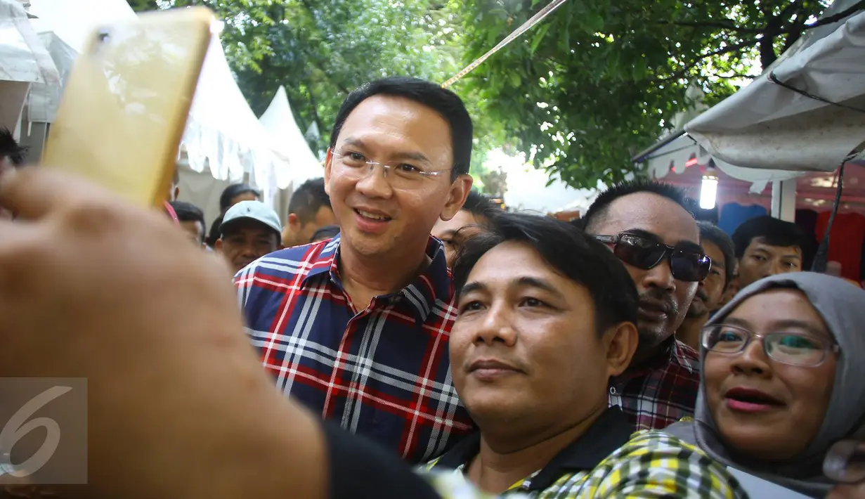 Warga berselfie dengan Cagub DKI Jakarta, Basuki T Purnama saat acara "Bersyukur Jakarta", Jumat (20/1). Dalam acara yang berbentuk bakti sosial dan pasar murah tersebut, terdapat hiburan dan permainan anak. (Liputan6.com/Immanuel Antonius)