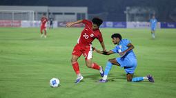 Pemain Timnas Indonesia U-23, Hokky Caraka (kiri) berebut bola dengan pemain India, Mohanan Vibin dalam laga uji coba di Stadion Madya, Senayan, Jakarta, Jumat (10/10/2025). (Bola.com/Muhammad Iqbal Ichsan)