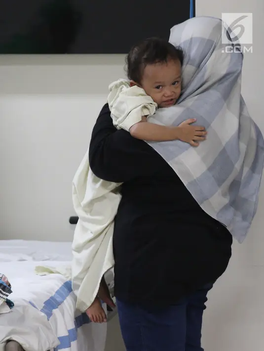 Seorang ibu menggendong sang anak sebelum masuk ruang operasi di RS EMC, Bogor, Jawa Barat, Sabtu (21/4). Operasi hernia yang diberikan oleh RS EMC dikhususkan bagi warga kurang mampu. (Liputan6.com/Herman Zakharia)