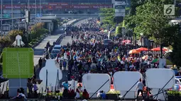 Warga berjalan di kawasan Jalan Jenderal Sudirman, Jakarta, Minggu (31/12). Meski Hari Bebas Kendaraan dipenghujung 2017 ditiadakan, warga tetap memadati kawasan sekitar Jalan Jend Sudirman dan MH Thamtin, Jakarta. (Liputan6.com/Helmi Fithriansyah)