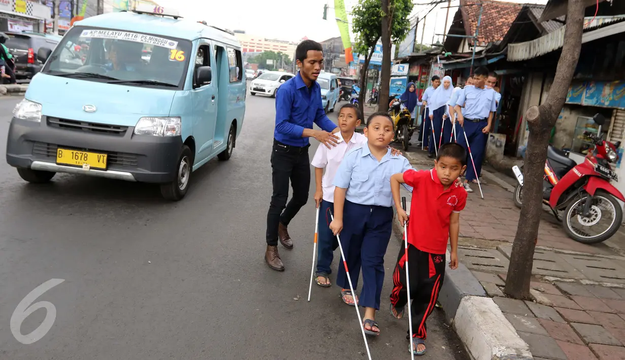 Guru membimbing siswa PSBN Cahaya Bathin penyandang tunanetra mengikuti praktik orientasi mobilitas di Cawang, Jakarta, Selasa (11/4). Praktik itu untuk melatih kemandirian siswa menghadapi situasi apapun dalam kesehariannya. (Liputan6.com/Gempur M Surya)