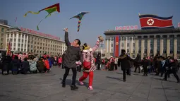 Dua anak bermain layang-layang saat merayakan hari libur Tahun Baru Imlek di alun-alun Kim Il Sung di Pyongyang, Korea Utara (16/2). Tahun Baru Imlek ternyata juga dirayakan warga Korea Utara. (AFP Photo/Kim Won-Jin)