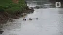 Sejumlah anak berenang di aliran Kali Ciliwung, Kampung Pulo, Jakarta, Jumat (2/12/2022).Minimnya lahan bermain menyebabkan anak-anak tersebut bermain tidak pada tempatnya, meskipun dapat membahayakan keselamatan. (merdeka.com/Imam Buhori)