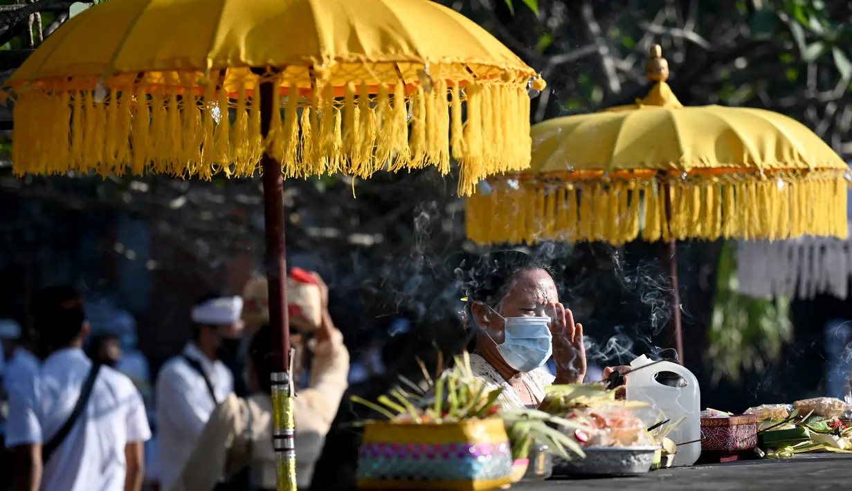 <p>Seorang perempuan umat Hindu berdoa saat mengikuti sembahyang perayaan hari raya Galungan di Pura Jagat Natha di Denpasar, Bali, Rabu (8/6/2022). Di tahun 2022 ini, Hari Raya Galungan jatuh pada tanggal 8 Juni dan diikuti Hari Raya Kuningan pada tanggal 18 Juni. (SONNY TUMBELAKA / AFP)</p>