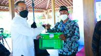 CEO PTPN V Jatmiko Santosa (kiri) berfoto bersama dengan salah seorang pemanen terbaik, Suherman Nasution. (Liputan6.com/M Syukur)