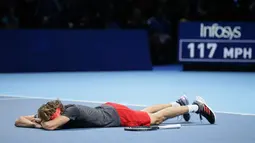 Petenis Jerman, Alexander Zverev tergeletak di lapangan setelah mengalahkan Novak Djokovic pada laga puncak ATP Finals 2018 di London, Senin (19/11). Zverev menjadi petenis termuda yang menjadi juara ATP Finals dalam satu dekade terakhir. (AP/Tim Ireland)