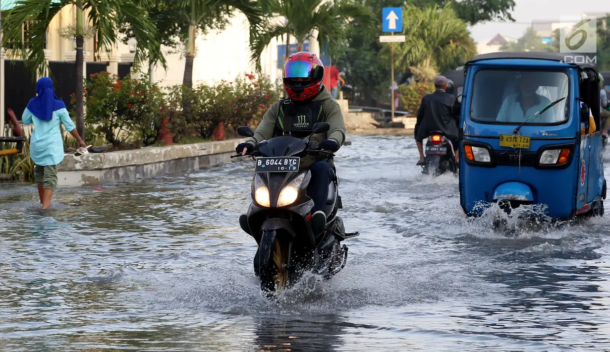 Pengendara menerobos banjir rob yang diakibatkan naiknya permukaan air laut di Muara Baru, Penjaringan, Jakarta Utara, Kamis (7/12). Banjir rob juga merendam ratusan rumah warga di Muara Baru dan Luar Batang. (Liputan6.com/Johan Tallo)