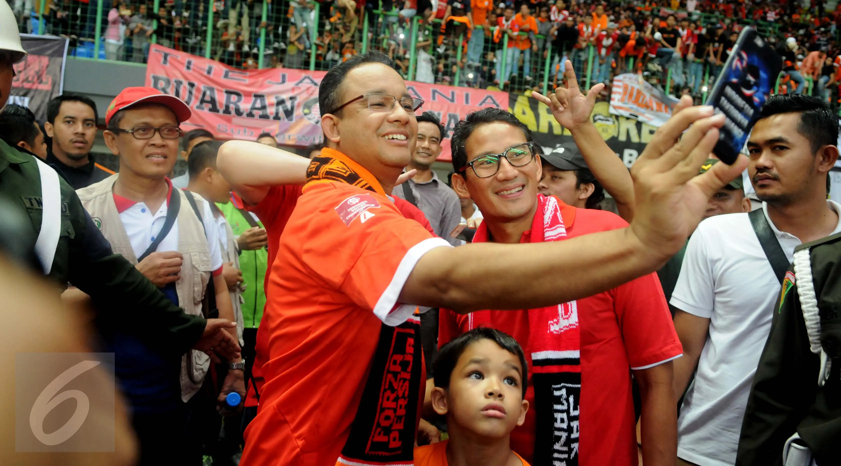 Calon Gubernur dan Wakil Gubernur DKI Jakarta Anies Baswedan bersama Sandiaga Uno berfoto usai menonton pertandingan Persija VS Barito Putra di Stadion Patriot Bekasi, Sabtu (22/4). (Liputan6.com/Gempur M. Surya)