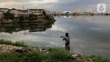 Warga memancing dekat pemukiman penduduk di kawasan Pluit, Jakarta, Kamis (10/12/2020). Wakil Gubernur DKI Jakarta Ahmad Riza Patria menyebutkan jumlah penduduk miskin di Jakarta meningkat 1,11 persen akibat terdampak pandemi Covid-19. (Liputan6.com/Immanuel Antonius)