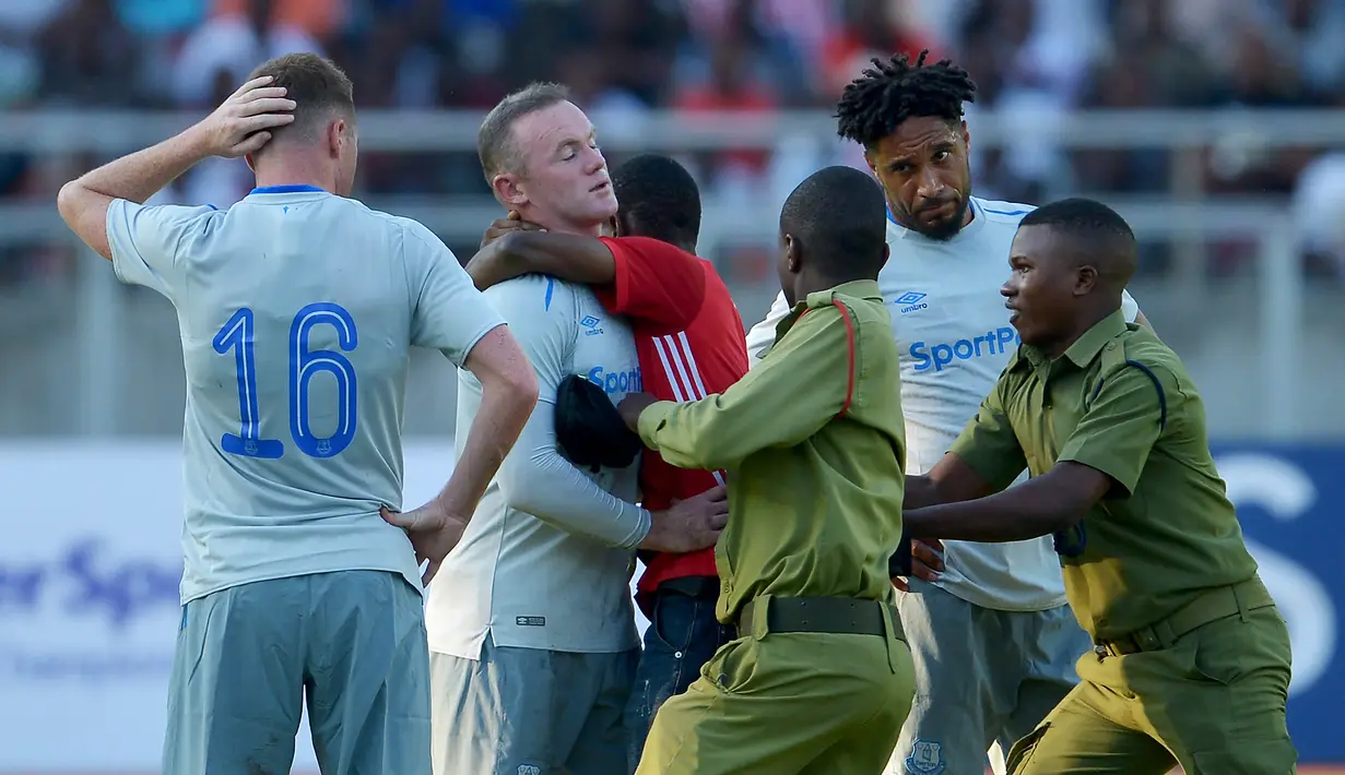 Seorang suporter turun ke lapangan dan memeluk Wayne Rooney pada laga persahabatan antara Everton dan Gor Mahia di SportsPesa Super Cup final di Dar-es-Salaam, (13/7/2017). (AFP/Tony Karumba)