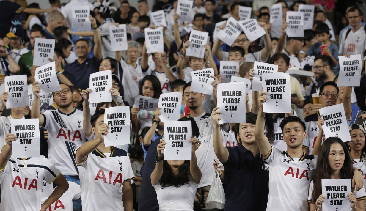 Fans Tottenham Hotspur memegang kertas bertuliskan permohonan untuk Kyle Walker tetap bertahan saat laga melawan Kitchee SC di  di Hong Kong, (26/5/2017). Tottenham menang 4-1. (AP/Kin Cheung)