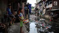 Dua orang anak bermain di pinggir kali di Tanah Abang, Jakarta, Senin (4/9). Tingkat kemiskinan itu didasarkan pada data Badan Pusat Statistik (BPS). (Liputan6.com/Angga Yuniar)