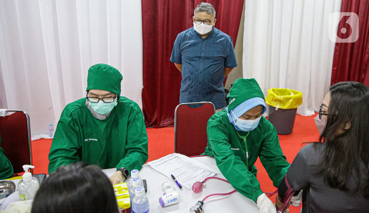 Petugas melakukan skrining pada pelaku usaha sebelum vaksin Covid-19 dosis kedua di Mall Tamrin City, Jakarta, Rabu (2/6/2021). Vaksinasi itu salah satu upaya pemerintah mematok target pertumbuhan ekonomi kembali positif sekitar 4,5 -5,3 persen di akhir 2021 ini. (Liputan6.com/Faizal Fanani)
