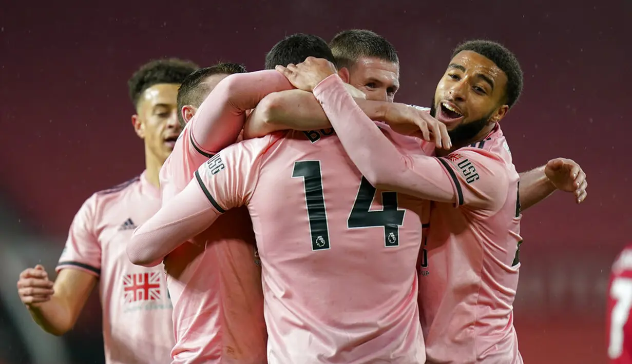 Pemain Sheffield United Oliver Burke (14) diberi selamat oleh rekan satu timnya setelah mencetak gol ke gawang Manchester United pada pertandingan Liga Inggris di Old Trafford, Manchester, Inggris, Rabu (27/1/2021). Sheffield United menang 2-1. (AP Photo/Tim Keeton, Pool)