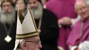 Paus Fransiskus membawa patung bayi Yesus selama memimpin misa Natal di Basilika Santo Petrus, Vatikan, (24/12). Ini merupakan Natal keenam bagi pria berusia 82 tahun ini sebagai kepala Gereja Katolik Roma. (AFP Photo/Tiziana Fabi)