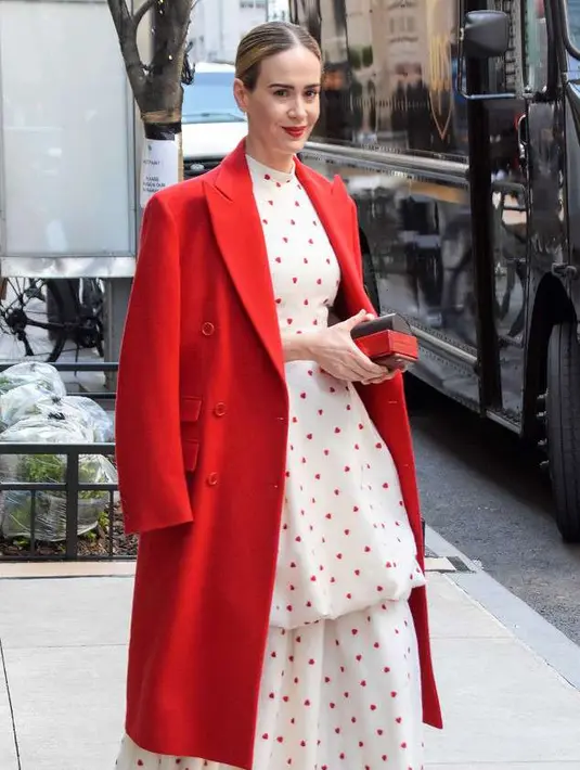 Penampilan Sarah Paulson dengan gaun polkadot putih dan merah yang dikombinasikan dengan trench coat merah dan heels warna senada juga nggak kalah manis. [@sarahpaulsbean]