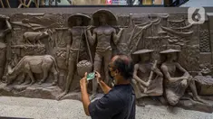 Pengunjung melihat relief peninggalan Bung Karno di pusat perbelanjaan Sarinah di Jakarta, Senin (21/3/2022). Relief bersejarah peninggalan Presiden pertama RI, IR Soekarno tersebut ditemukan di Basement Gedung Sarinah saat pemugaran pada awal Januari 2021 lalu. (Liputan6.com/Faizal Fanani)