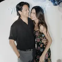 Sementara itu, Deva Mahenra sang suami mengenakan atasan kemeja hitam lengan pendek dipadukan celana panjang abu-abu dan belt hitamnya. [@miktambayong]