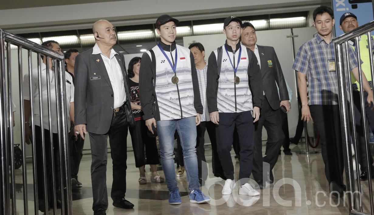 Pebulutangkis ganda putra Indonesia, Kevin Sanjaya/Marcus Gideon, tiba di Bandara Soekarno Hatta. Mereka kembali ke tanah air usai meraih gelar All England usai menundukan pasangan China, Li Junhui/Liu Yuchen. (Bola.com/M Iqbal Ichsan)
