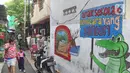 Warga melintas di Kampung Literasi RW 08, Jatipulo, Palmerah, Jakarta Barat, Kamis (30/1/2020). Kampung Literasi ini memiliki 5 kotak berisi beragam buku yang ada di sejumlah titik, berbekal konsep kejujuran disebar di sepanjang kampung. (Liputan6.com/Herman Zakharia)