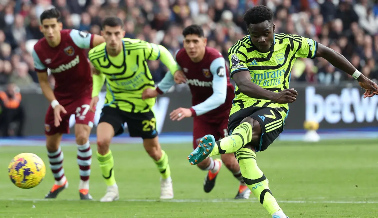 Tiga kemenangan tandang beruntun Arsenal dengan selisih lima gol lebih dimulai pada laga pekan ke-24 saat Arsenal mengalahkan tuan rumah West Ham United di London Stadium dengan skor 6-0 (11/2/2024). Lima pemain berhasil mencatatkan namanya di papan skor, yaitu William Saliba (32'), Bukayo Saka (penalti 41') dan (63'), Gabriel Magalhaes (44'), Leandro Trossard (45+2) dan Declan Rice (65'). (AFP/Adrian Dennis)