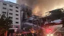 Petugas pemadam kebakaran menyemprotkan air ke lokasi kebakaran di hotel-kasino Grand Diamond City di Poipet pada 29 Desember 2022. Sebanyak 10 orang tewas dalam kebakaran di hotel-kasino Kamboja di perbatasan Thailand, dengan foto menunjukkan kelompok mati-matian meringkuk di tepian saat api yang ganas mengelilingi mereka. (AFP/STR)