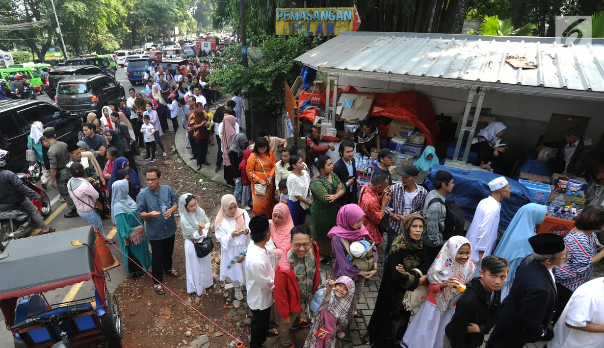 Warga antre masuk ke dalam Istana Bogor saat kegiatan open house Presiden Joko Widodo di Jalan Ir.H.Djuanda, Bogor (15/6). Ribuan warga antre untuk bersalaman mengucapkan selamat Idul Fitri  1439 H. (Merdeka.com/Arie Basuki)